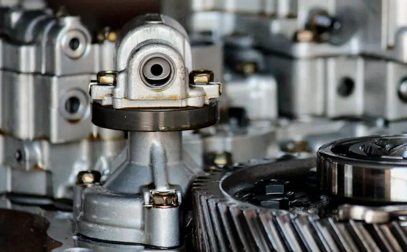 Illustration: close-up of aluminium gearbox housings and a gear wheel in a workshop