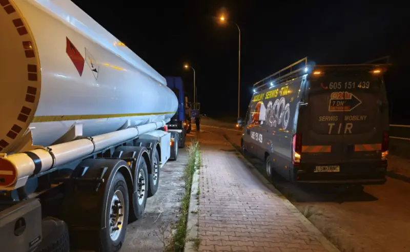 Mobile truck service van at night on the roadside behind a tanker semi-trailer