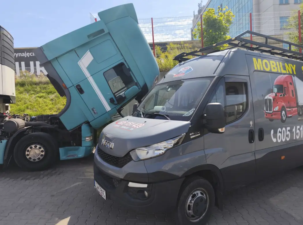 Mobile service van beside a turquoise DAF tractor unit with its cab tilted in a car park