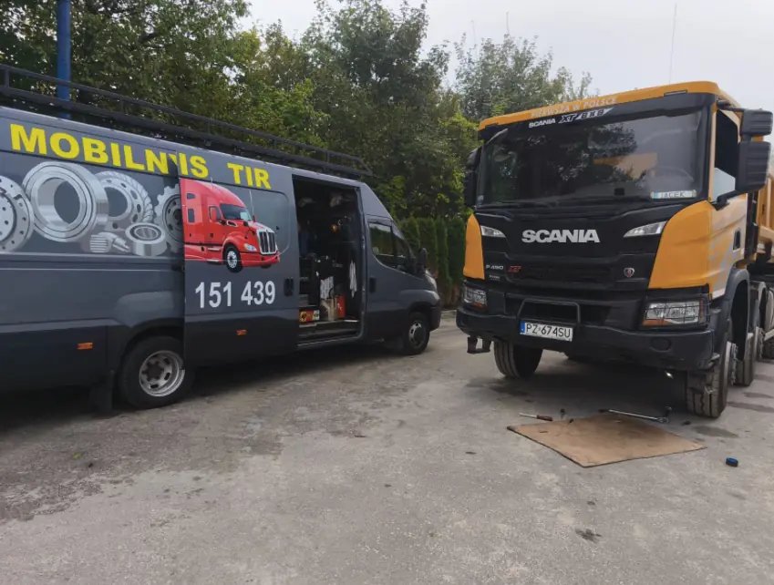 Mobile truck service van parked beside an orange Scania XT tipper during an on-site repair