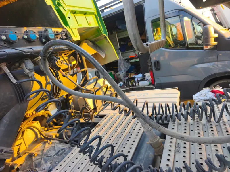 Coiled air and electrical lines on the chassis of a tractor unit with its cab tilted